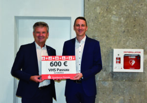 Sparkasse Passau spendet 600 Euro für Defibrillator an Volkshochschule Passau